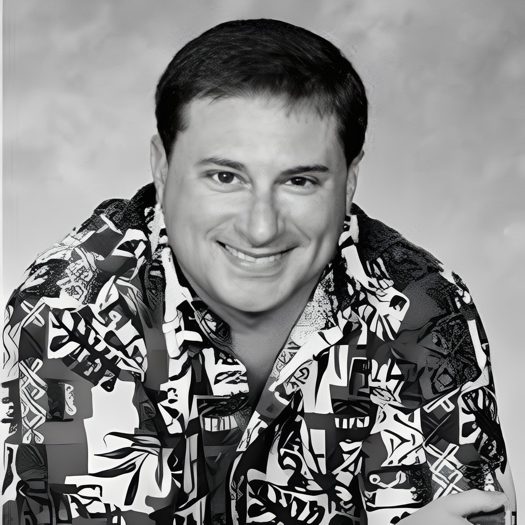 Black-and-white smiling man in patterned shirt