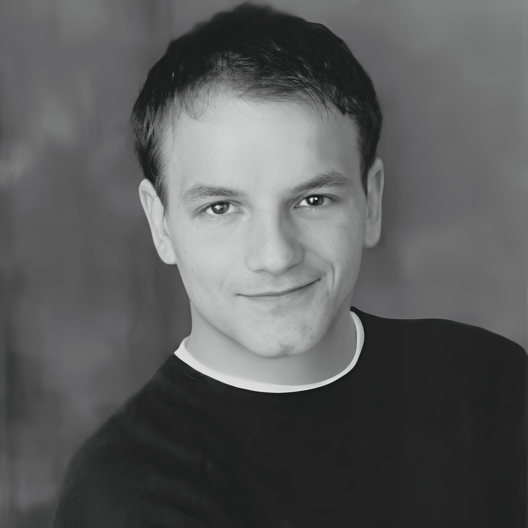 black and white headshot of smiling young man