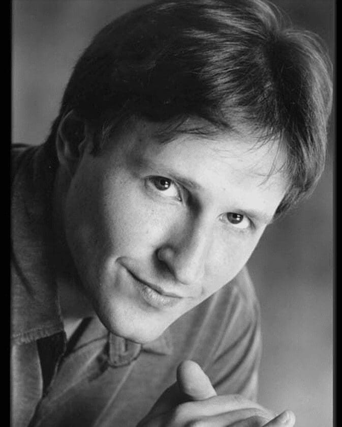 Black-and-white close-up smiling man headshot