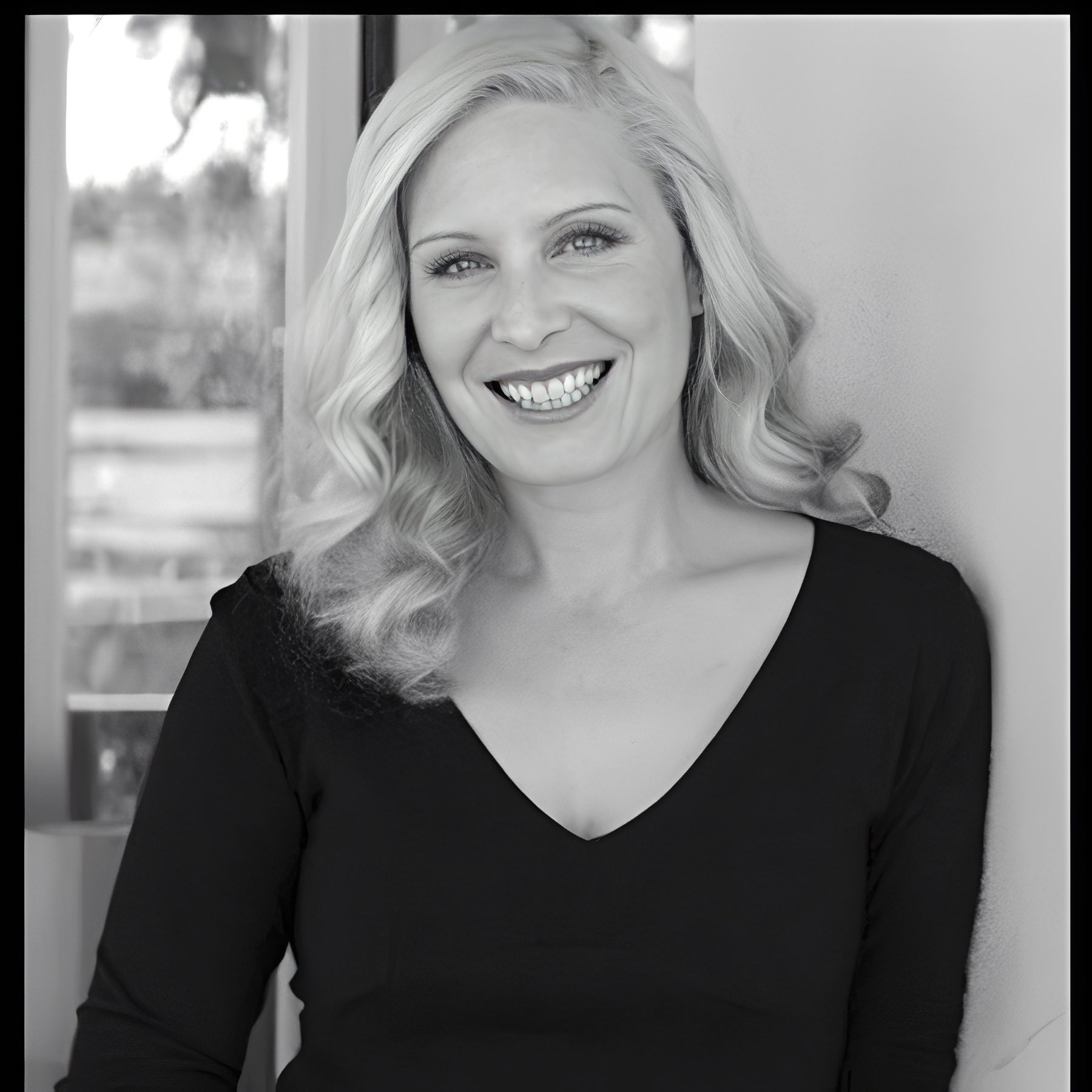 Smiling blonde woman in black top