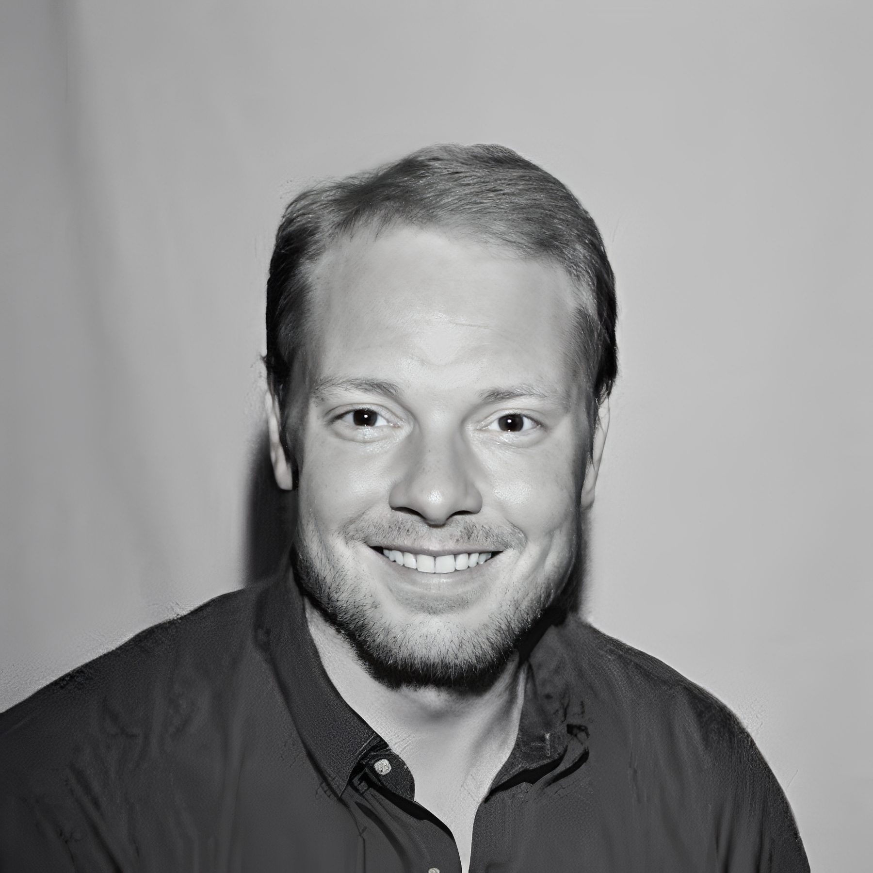 Smiling bearded man against plain background
