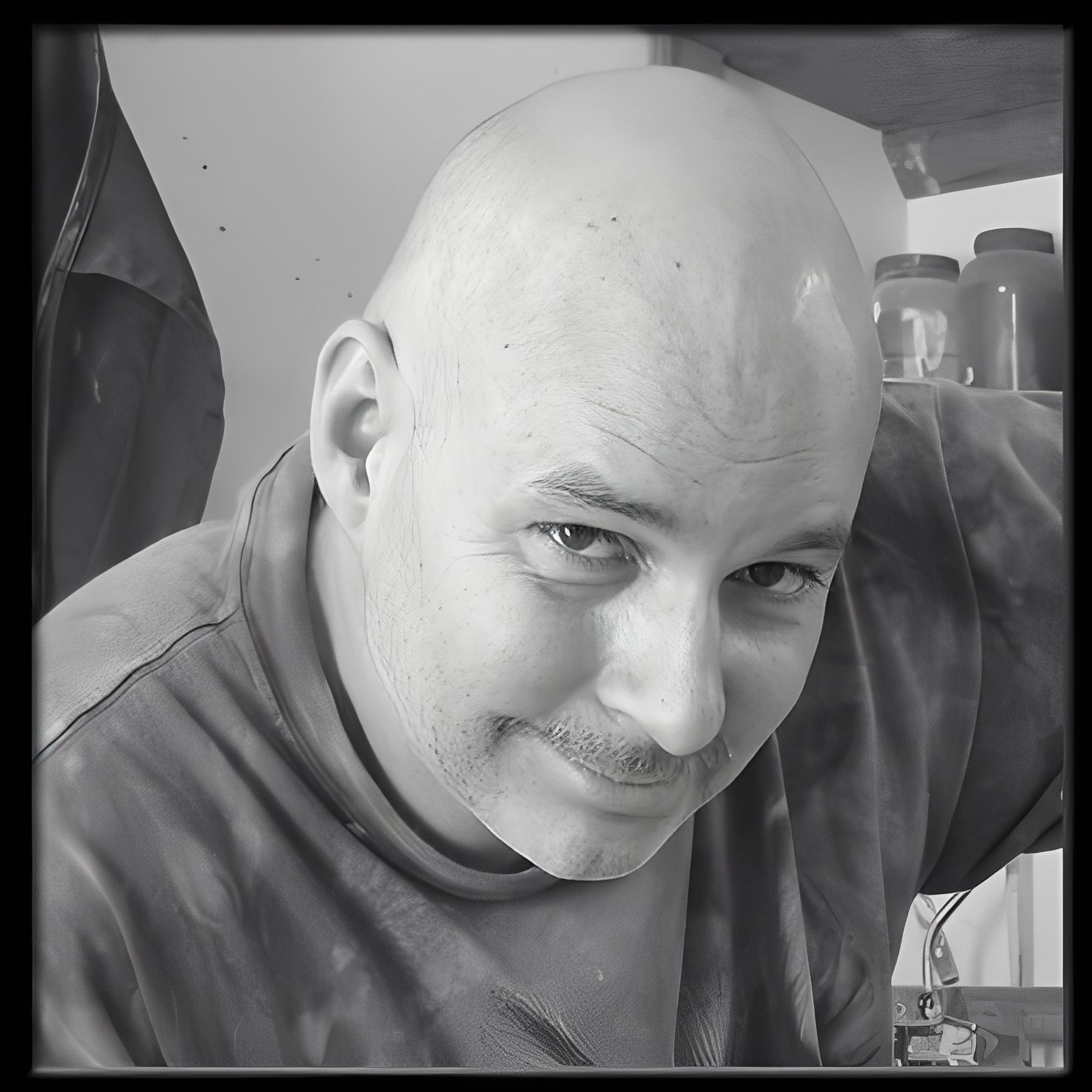 Smiling bald man leaning toward camera